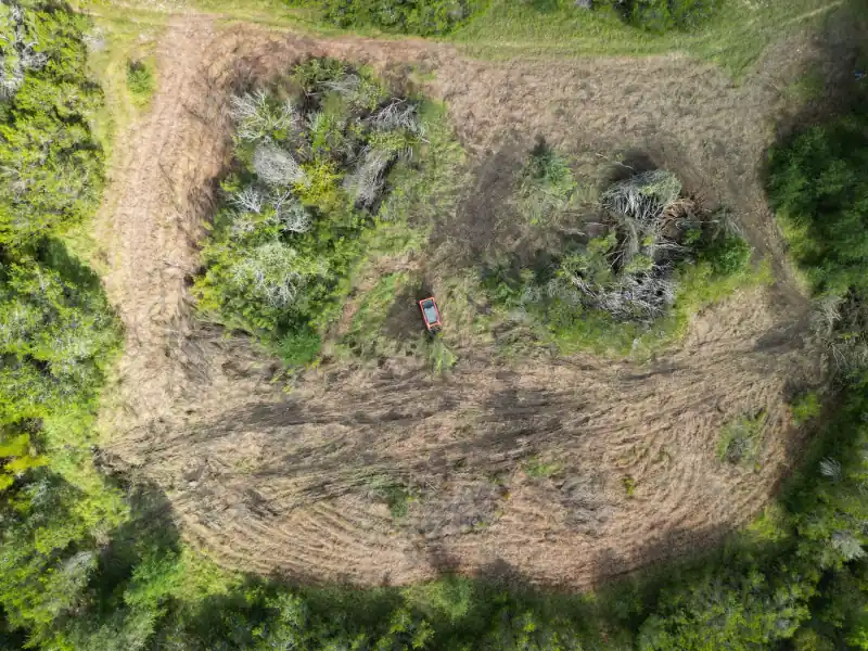 Aerial view of a forestry mulcher clearing brush in South Central Texas
